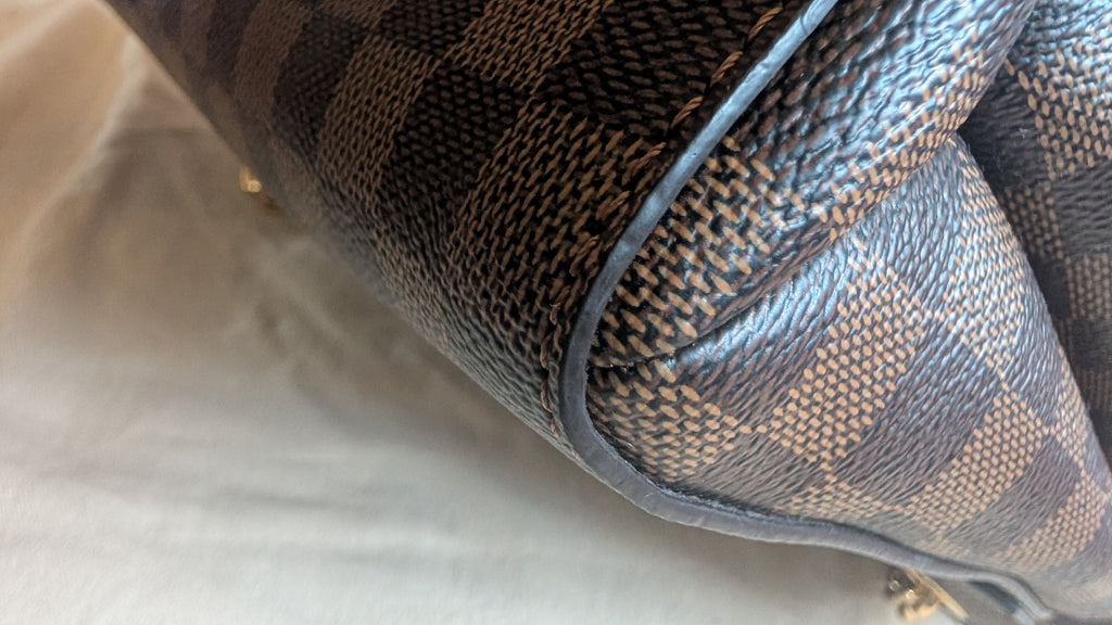 Close-up of a Louis Vuitton handbag in the Damier Ebene check pattern, featuring dark brown and beige checkered canvas with dark brown  Pre-Owned Louis Vuitton Vavin PM Damier Ebene / Crème – N40113leather trim.