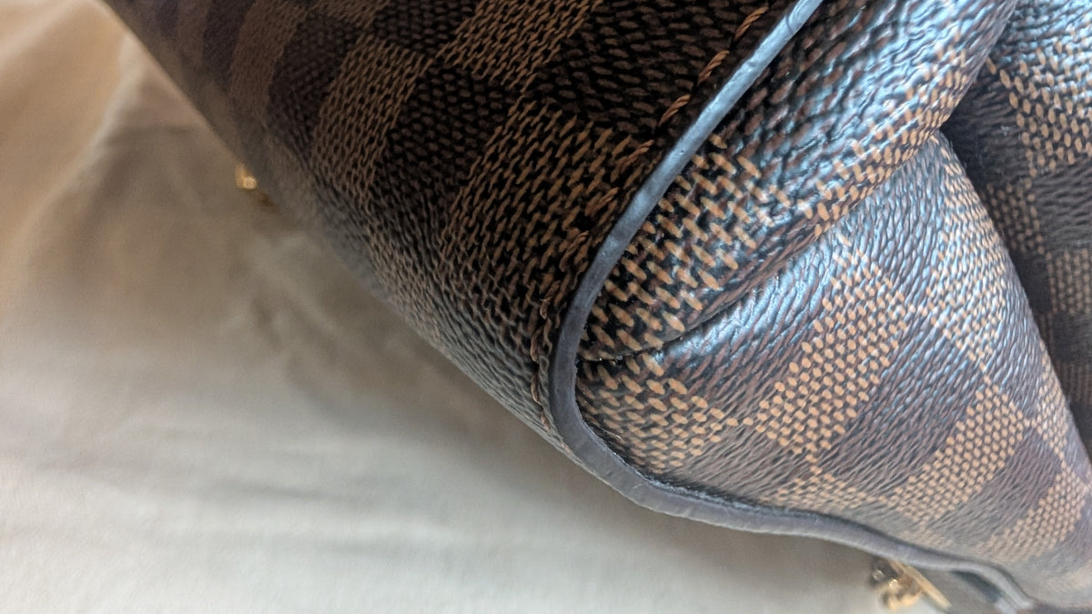 Close-up of a Louis Vuitton handbag in the Damier Ebene check pattern, featuring dark brown and beige checkered canvas with dark brown  Pre-Owned Louis Vuitton Vavin PM Damier Ebene / Crème – N40113leather trim.