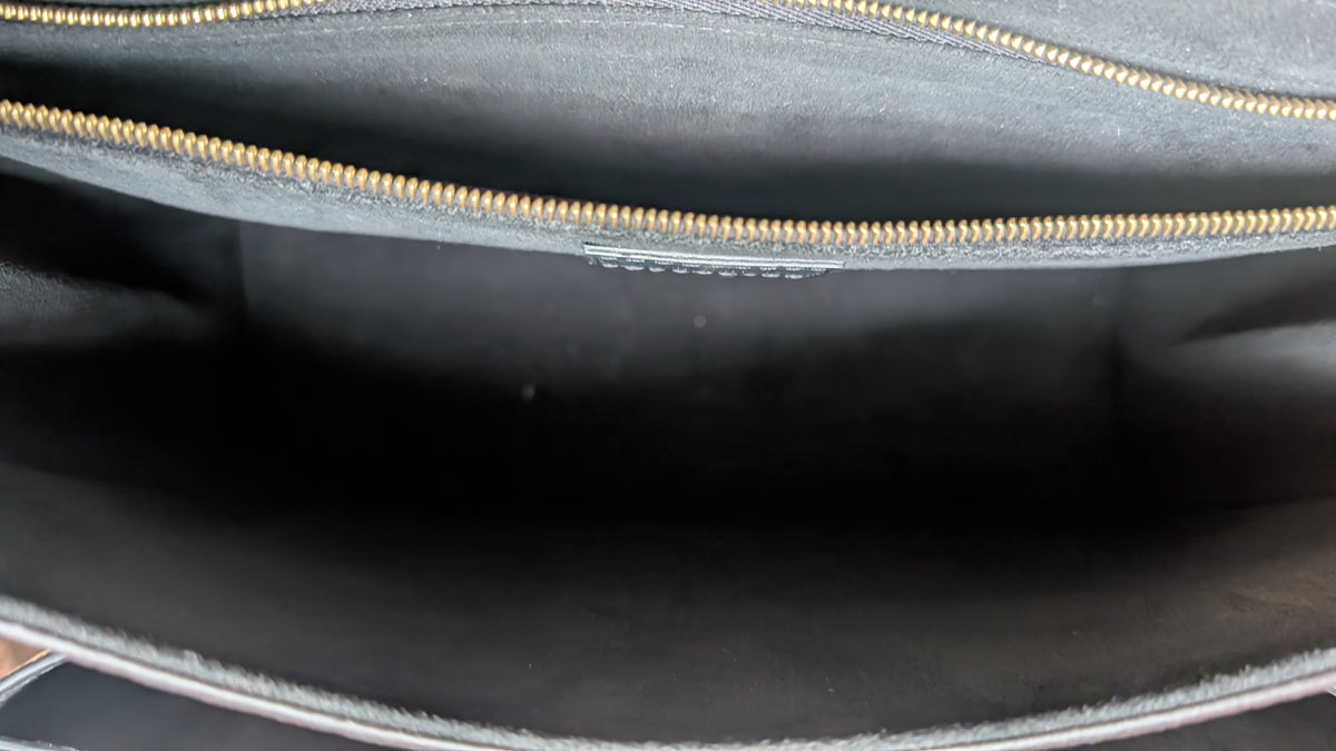 Close-up view of the interior of a black bag, showing a dark fabric lining and a gold zipper along the top edge. Pre-Owned Louis Vuitton Vavin PM Damier Ebene / Crème – N40113