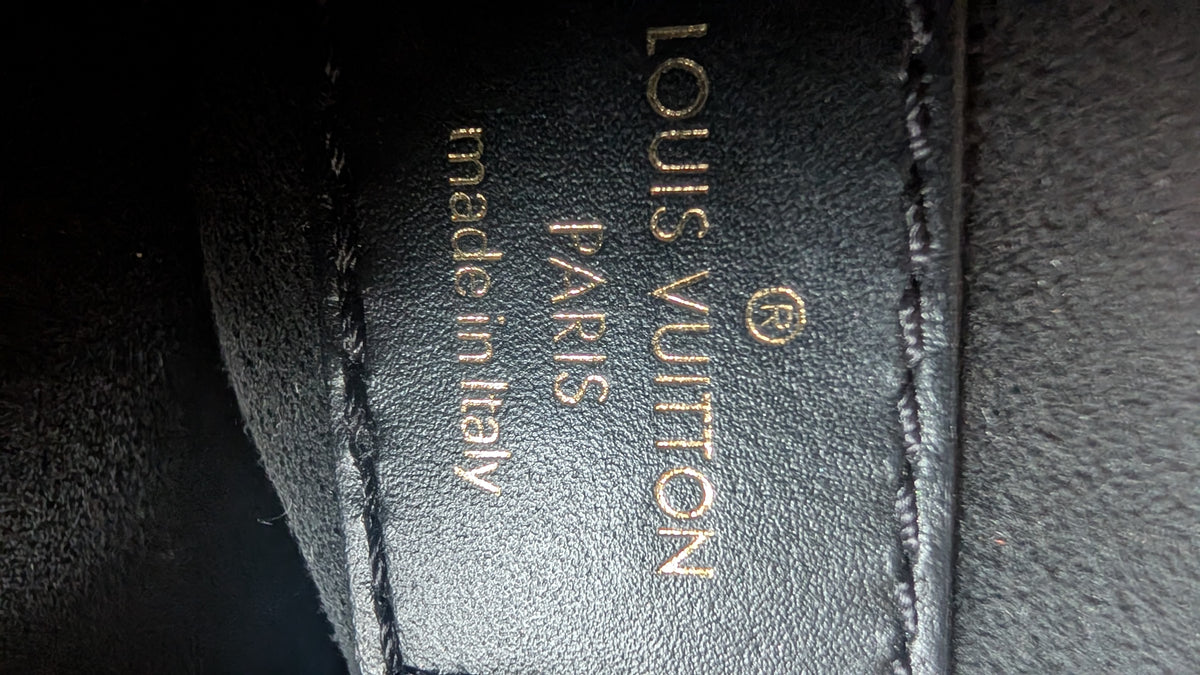 Close-up of a black leather Louis Vuitton product with gold embossed text reading 'LOUIS VUITTON', 'PARIS', and 'made in Italy'. Pre-Owned Louis Vuitton Vavin PM Damier Ebene / Crème – N40113