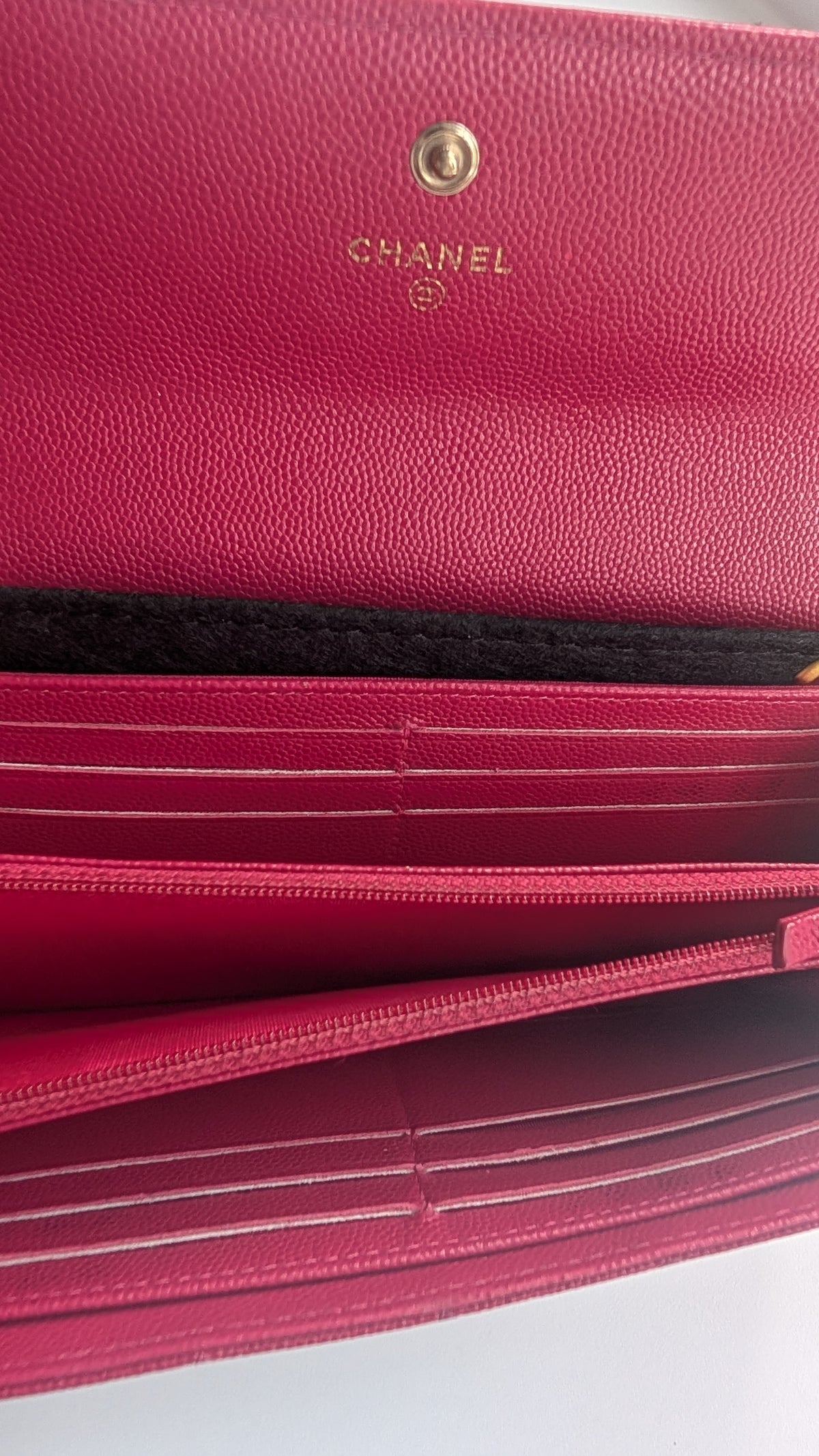 Close-up of a Chanel long wallet in textured pink leather, showing the gold CHANEL logo, interior card slots, and zipper. Pre-Owned Chanel Boy Wallet on Chain – Fuchsia Pink Caviar Leather – Gold Hardware