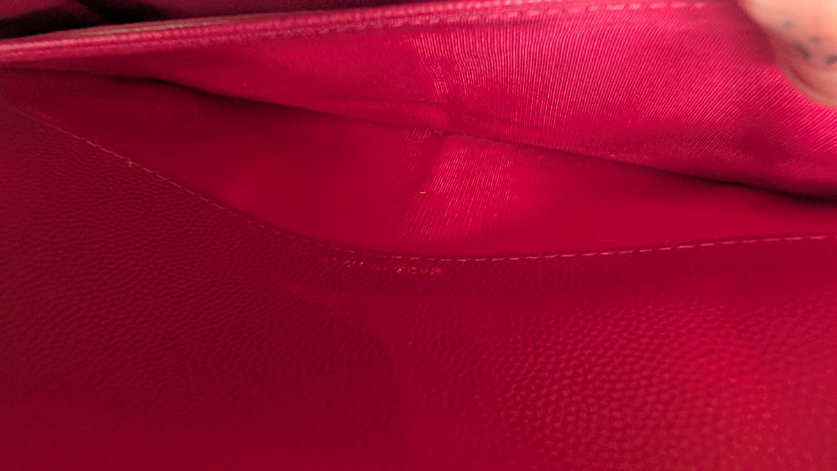 Close-up of a vibrant magenta pink textured leather interior, showing fine grain and stitching details. Pre-Owned Chanel Boy Wallet on Chain – Fuchsia Pink Caviar Leather – Gold Hardware