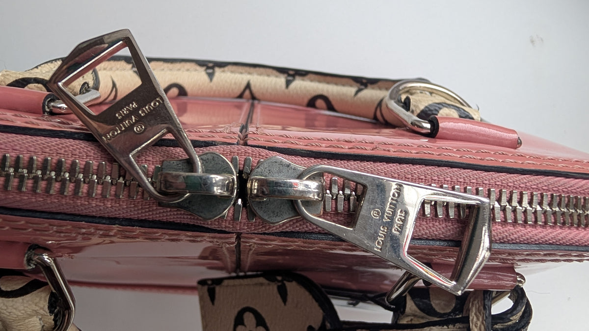 Close-up of a pink Louis Vuitton handbag with silver-tone hardware and a beige monogram strap against a plain light background. Pre-Owned LOUIS VUITTON ALMA BB – ROSE BLUSH MONOGRAM VERNIS MIROIR