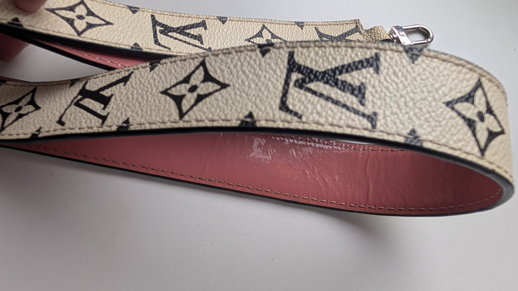 A Louis Vuitton shoulder strap in beige Monogram canvas with black printed logos, featuring a pink leather lining and a silver metal clasp, shown on a light gray background. Pre-Owned LOUIS VUITTON ALMA BB – ROSE BLUSH MONOGRAM VERNIS MIROIR