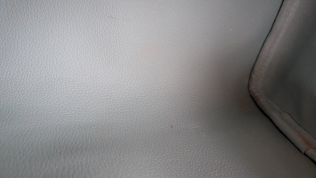 Close-up of a light gray textured material corner with a darker seam along the right edge. Pre-Owned Louis Vuitton x Richard Prince Limited Edition Monogram Bag – Spring/Summer 2008 – Pale Blue
