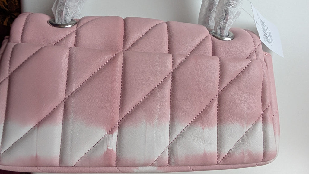 A close-up of a quilted pink handbag with a diagonal diamond pattern, featuring silver-tone metal hardware and a white price tag attached. Pre-Owned Coach Tabby 20 Quilted Nappa Leather Shoulder Bag – Pink & White Ombré