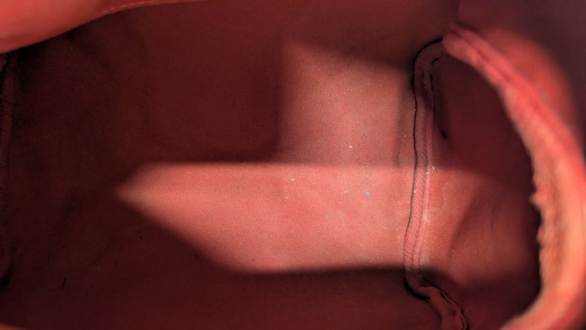 Close-up view of the interior lining of a pink or dusty rose fabric bag, showing stitched edges and a soft shadow across the surface. Pre-Owned Louis Vuitton Speedy 25 Damier Ebene Coated Canvas Bag DU4151