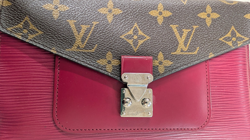 Close-up of a Louis Vuitton handbag showing the brown monogram flap with gold LV logos, a magenta pink leather body, and a silver-tone turn-lock clasp. Pre-Owned Louis Vuitton Portefeuille Marie-Rose Clutch Wallet – Fuchsia Epi Leather & Monogram Canvas